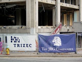 Along the perimeter fence hang banners for Trizec and The JBG Companies.