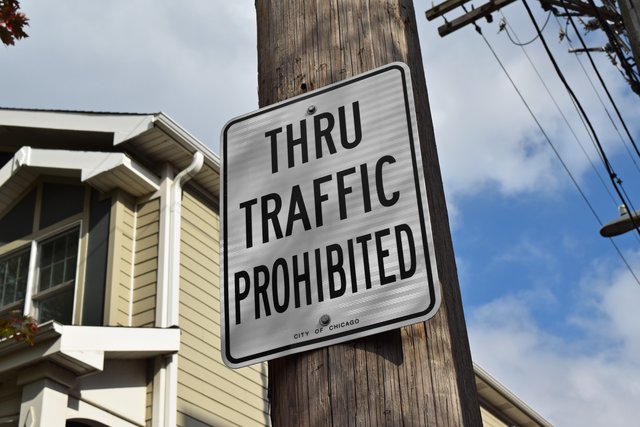 Sign indicating a prohibition on through traffic in an alley between North Claremont and North Oakley Avenues.