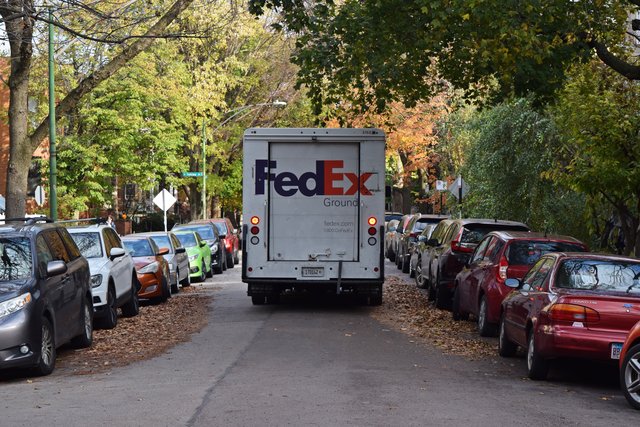 A FedEx truck travels eastbound on West Giddings Street.