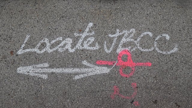 Markings on the pavement for utility work by John Burns Construction.