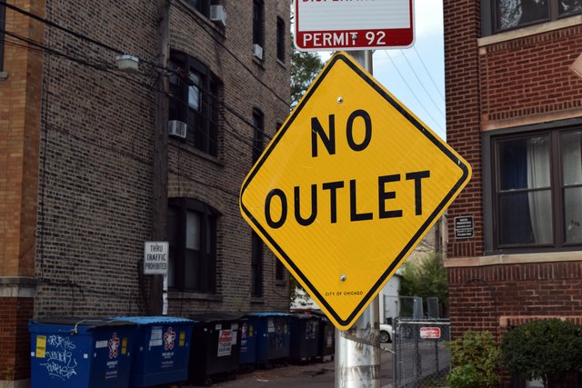 "NO OUTLET" sign on the north side of the alley's intersection with West Leland Avenue.  This sign is incorrect, as the alley does go through, though other signage prohibits through traffic.