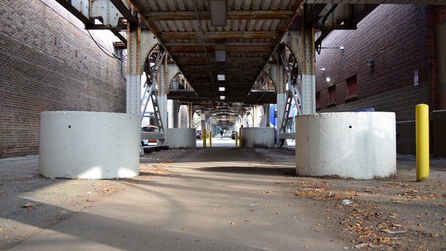 A line of concrete planters beneath the Brown Line tracks to the west of North Lincoln Avenue.