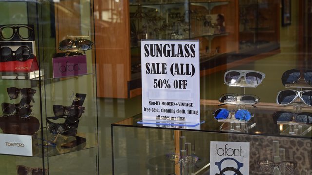 Sign advertising a sale on sunglasses at Quality Optical.