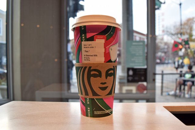 A cup of steamed milk from Starbucks, for "Pen".